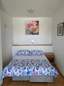 a bedroom with a bed with a blue and white comforter at Apartments with a parking space Smrika, Kraljevica - 14812 in Šmrika