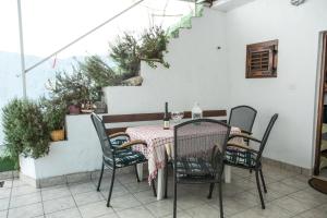 a table and chairs on a patio with stairs at Apartments by the sea Krilo Jesenice, Omis - 14823 in Krilo +11 photos