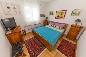a small bedroom with a bed and a television at Apartment Arbanija 14825b in Trogir