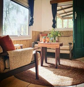 a living room with a table and chairs and a window at Gum Grove Chalets in Denmark