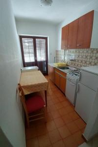 małą kuchnię ze stołem i kuchenką w obiekcie Apartment Novalja 13006c w Novalji