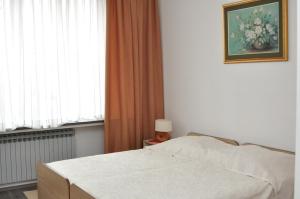 a bedroom with a white bed and a window at Rooms with a parking space Zagreb - 14837 in Zagreb