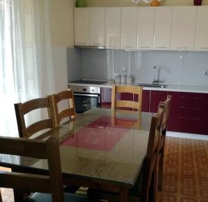a kitchen with a wooden table and chairs and a kitchen with white cabinets at Apartments with WiFi Omis - 14843 in Omiš