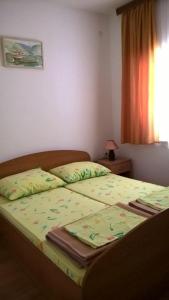 ein Bett mit zwei Kissen darauf in einem Schlafzimmer in der Unterkunft Apartments with a parking space Orebic, Peljesac - 14857 in Orebić
