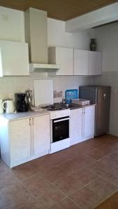 eine Küche mit weißen Schränken, einem Herd und einem Kühlschrank in der Unterkunft Apartments with a parking space Orebic, Peljesac - 14857 in Orebić + 11 Fotos