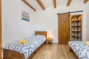 a bedroom with two beds and a wooden floor at Holiday house with a parking space Risika, Krk - 14860 in Vrbnik