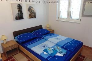 スチュライにあるApartments by the sea Sucuraj, Hvar - 14866の青いシーツのベッドと彫像のある寝室