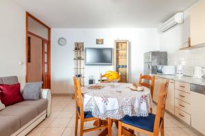 eine Küche und ein Esszimmer mit einem Tisch und einem Sofa in der Unterkunft Seaside holiday house Karbuni, Korcula - 14889 in Prizba