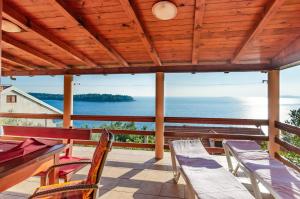 eine Veranda mit Stühlen und einem Tisch sowie Meerblick in der Unterkunft Seaside holiday house Karbuni, Korcula - 14889 in Prizba