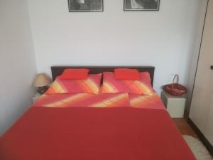 - un lit rouge avec des oreillers rouges dans une chambre dans l'établissement Apartments with a parking space Zagreb - 14890, à Zagreb