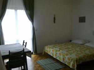 een slaapkamer met een bed, een tafel en een raam bij Apartments and rooms with parking space Stari Grad, Hvar - 14888 in Stari Grad