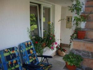 a patio with a chair and some plants and flowers at Apartments with a parking space Delnice, Gorski kotar - 14895 in Delnice