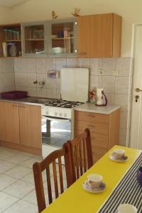 een keuken met een fornuis en een tafel met stoelen bij Seaside secluded apartments Cove Skozanje, Hvar - 14899 in Gdinj