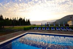Una piscina con tumbonas y una montaña. en Luxury villa with a swimming pool Zastolje, Dubrovnik - 14922, en Gruda