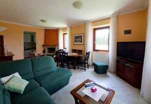 Una sala de estar con un sofá verde y una mesa. en Luxury villa with a swimming pool Zastolje, Dubrovnik - 14922, en Gruda