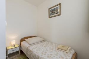niewielka sypialnia z łóżkiem i zdjęciem na ścianie w obiekcie Apartments with WiFi Split - 14921 w Splicie