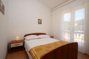 a bedroom with a bed and a large window at Apartments by the sea Prizba, Korcula - 14940 in Prizba