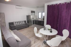 a living room with a couch and a table and chairs at Apartments with parking space Sumpetar, Omis - 14941 in Jesenice +16 photos