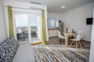 a living room with a couch and a table with chairs at Apartments with parking space Sumpetar, Omis - 14941 in Jesenice