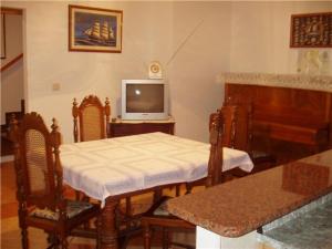 uma sala de estar com uma mesa e uma televisão em Apartments with a parking space Mali Losinj (Losinj) - 14944 em Mali Lošinj