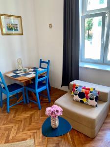 ein Wohnzimmer mit einem Tisch und einem Sofa in der Unterkunft Apartments and rooms by the sea Opatija - 14937 in Opatija