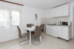 a kitchen with a table and chairs and a microwave at Apartments by the sea Stomorska, Solta - 14960 in Stomorska