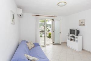 a living room with a blue couch and a tv at Apartments by the sea Stomorska, Solta - 14960 in Stomorska