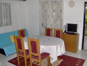 a dining room with a table and chairs and a tv at Apartments with a parking space Milna, Brac - 14961 in Milna