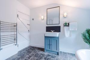 uma casa de banho com um lavatório azul e um espelho. em Charming 3 Bed Home in the Garden Quarter, Chester em Chester