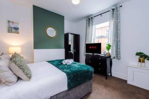 um quarto com uma cama e uma televisão em Charming 3 Bed Home in the Garden Quarter, Chester em Chester