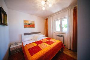 a bedroom with a bed with a colorful quilt at Apartments by the sea Podstrana, Split - 14982 in Podstrana