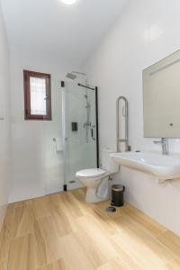 biała łazienka z toaletą i umywalką w obiekcie Córdoba Suites Apartments w Kordobie