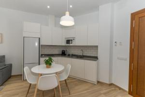 Córdoba Suites Apartments في قرطبة: مطبخ مع طاولة وكراسي في غرفة