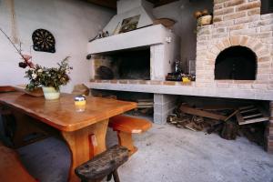 a room with a table and a brick fireplace at Apartment Preko 14985b in Preko