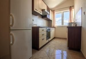 a kitchen with a white refrigerator and a window at Apartment Preko 14985b in Preko