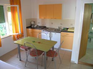 a kitchen with a table and chairs and a sink at Apartments with a parking space Smokvica Krmpotska, Novi Vinodolski - 14995 in Klenovica