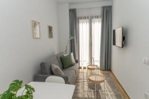 ein Wohnzimmer mit einer Couch und zwei Tischen in der Unterkunft Córdoba Suites Apartments in Córdoba