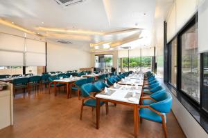 a dining room with tables and blue chairs at Enrise by Sayaji Aurangabad in Aurangabad