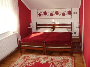 Kneževi VinogradiにあるTwin Room Knezevi Vinogradi 15024dの赤い壁のベッドと赤いラグが備わるベッドルーム1室が備わります。
