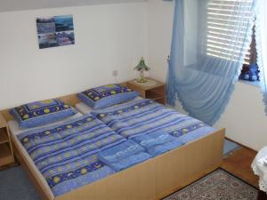 um quarto com uma cama com lençóis azuis e uma janela em Family Room Knezevi Vinogradi 15024a em Kneževi Vinogradi