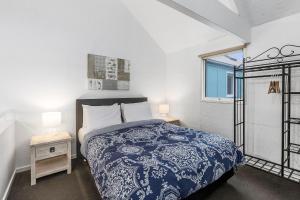 a bedroom with a blue and white bed and a window at Terrace Lofts Apartments in Ocean Grove
