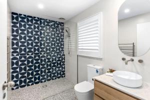 a bathroom with a toilet and a sink and a mirror at Terrace Lofts Apartments in Ocean Grove