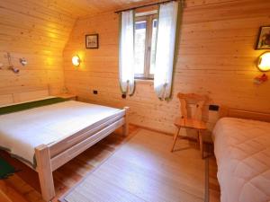 a bedroom with a bed and a chair in a cabin at Holiday house with a parking space Crni Lug, Gorski kotar - 15058 in Crni Lug