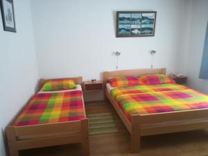 Apartments with a parking space Lokve, Gorski kotar - 15061 في لوكفا: غرفة نوم مع سريرين مع بطانيات ملونة