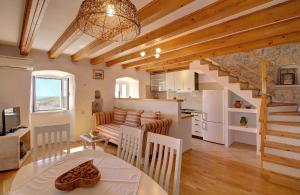 a kitchen and living room with a table and a dining room at Family friendly house with a swimming pool Babino Polje, Mljet - 14926 in Babino Polje