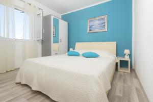 a bedroom with a large white bed with blue walls at Apartments by the sea Cove Pribinja, Hvar - 15083 in Hvar