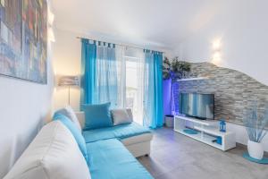 a living room with a blue couch and a tv at Apartments by the sea Cove Pribinja, Hvar - 15083 in Hvar