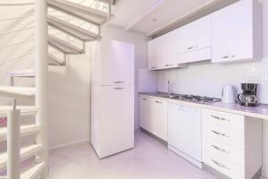 a white kitchen with white cabinets and a staircase at Apartments by the sea Cove Pribinja, Hvar - 15083 in Hvar