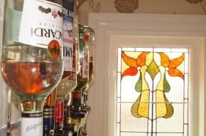 a glass of wine next to a door with a stained glass window at The Beechcliffe Hotel - Over 35's Only in Blackpool +16 photos