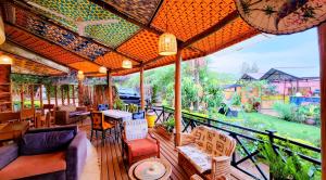 een patio met tafels en stoelen op een balkon bij Yambi Guesthouse in Kigali